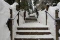 A photo of an outdoor staircase covered in snow, shoveled on the steps, but high walls of snow around the staircase Royalty Free Stock Photo