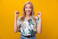 Photo of overjoyed ecstatic girl with long hairdo dressed shirt clenching fists shout supporting you isolated on yellow