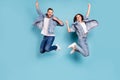 Photo of overjoyed joyful cute nice couple of spouses jumping flying in air happily while with blue background