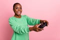 Photo of overjoyed satisfied lady hold controller addicted play games isolated on pink color background