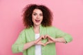 Photo of overjoyed woman with perming coiffure dressed shirt hands showing heart astonished staring isolated on pink