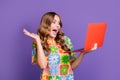 Photo of overjoyed woman with wavy hair wear stylish t-shirt staring at unbelievable sale in laptop isolated on purple Royalty Free Stock Photo