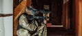 Photo of paintball player in goggle mask and camouflage aiming by paintball gun. Selective focus Royalty Free Stock Photo