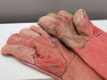 Photo of a pair used welding hand glove.