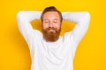 Photo of peaceful glad person closed eyes arms behind head sleep isolated on yellow color background