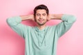 Photo of peaceful glad young man closed eyes arms behind head take nap isolated on pink color background