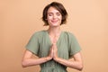 Photo of peaceful serene lady hold palms together close eyes wear green dress isolated beige color background