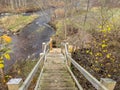 Pedestrian wooden stairs, tree leaves on footbridge, autumn day