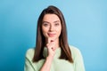 Photo of pensive charming girl finger chin look camera smile wear green sweater isolated blue color background