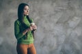 Photo of pensive thoughtful interested woman holding cup of hot beverage in ornage pants trousers looking into empty Royalty Free Stock Photo