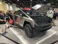 People Admiring the Futuristic Tesla Cybertruck at the Auto Show