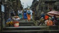 Photo of people walking on the rock stears in a sacred place with ancient stone buildings on the island of bali