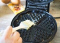 Photo of a person greasing a waffle iron pan