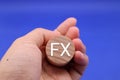 A person holding building blocks with FX written on them