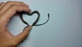 a photo of a person holding a heart-shaped brown bracelet Royalty Free Stock Photo