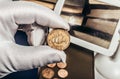 Photo of a person's hand in gloves holding a british coin