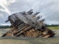 A photo of the pesuta shipwreck, a wooden shipwreck lying on a sandy beach, in Naikoon Provincial Park, Haida Gwaii, British Colum