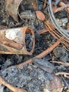 A photo of a pile of waste that traces its burning and over time rusts objects