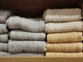 Photo of piles multi colored cotton towels on the shelf in the shop.