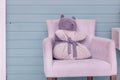 Pillow in the form of a bear on a soft purple chair that stands against a wooden wall Royalty Free Stock Photo