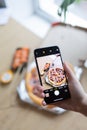Photo of pizza on phone with hand Royalty Free Stock Photo