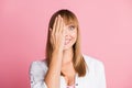 Photo of playful childish girl palm close eye cheerful smile wear white blouse isolated pink color background Royalty Free Stock Photo