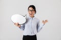 Photo of pleased female worker wearing eyeglasses holding blank thought bubble, isolated over white background
