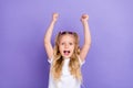 Photo portrait of adorable little girl tails raise fists overjoyed good mark wear stylish white garment on