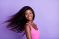 Photo portrait of african american smiling girl swinging hair on pastel pink colored background