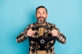 Photo portrait of aged man driving car keeping steering wheel smiling isolated on vivid blue color background Royalty Free Stock Photo