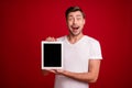 Photo portrait of amazed shocked entrepreneur showing tablet touchscreen blank space opened mouth isolated bright red