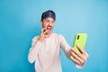 Photo portrait of angry guy yelling holding phone in one hand isolated on vivid blue colored background Royalty Free Stock Photo