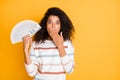 Photo portrait of astonished speechless voiceless quiet girl closing her mouth with palm holding stack of american money