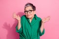 Photo portrait of attractive pensioner woman shrug shoulders no idea wear trendy green clothes isolated on pink color