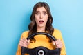 Photo portrait of attractive young girl steering wheel astonished confused wear trendy yellow garment isolated on blue