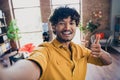 Photo portrait of attractive young man wear yellow shirt streaming selfie photo thumb up modern workplace room home