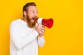 Photo portrait of attractive young man yell hold loudspeaker empty space wear stylish white clothes isolated on yellow Royalty Free Stock Photo