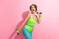 Photo portrait of attractive young woman excited dumbbells training dressed stylish green sport jumpsuit isolated on Royalty Free Stock Photo