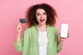 Photo portrait of attractive young woman hold credit card hold device screen wear trendy green clothes isolated on pink Royalty Free Stock Photo