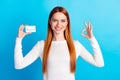 Photo portrait of attractive young woman hold credit card okey dressed stylish white clothes isolated on blue color Royalty Free Stock Photo