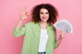 Photo portrait of attractive young woman hold money fan show okey symbol wear trendy green clothes isolated on pink Royalty Free Stock Photo