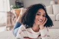 Photo portrait of attractive young woman lying floor cheerful smile dressed casual clothes cozy day light home interior Royalty Free Stock Photo