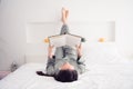 Photo portrait of attractive young woman lying upside down read book wear trendy gray pajama isolated on white modern Royalty Free Stock Photo