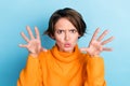 Photo portrait of attractive young woman raise hands frighten boo funky fooling wear trendy orange look isolated on blue Royalty Free Stock Photo