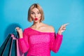 Photo portrait of attractive young woman shopping bags point empty space wear trendy pink knitted clothes  on Royalty Free Stock Photo