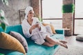 Photo portrait of attractive young woman sit sofa hold telephone head wrapped towel dressed bath robe home interior Royalty Free Stock Photo