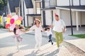 Photo portrait of big family running together wearing birthday cones lifting small boy up outdoors on street in summer Royalty Free Stock Photo