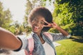 Photo portrait of black skinned beautiful girl taking selfie in summer park smiling showing v-sign peace wearing casual Royalty Free Stock Photo