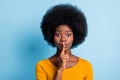 Photo portrait of black skinned girl keeping finger near lips speechless quietly isolated on vibrant blue color