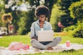 Photo portrait of black skinned young female student studying doing project on laptop sitting in park wearing glasses Royalty Free Stock Photo